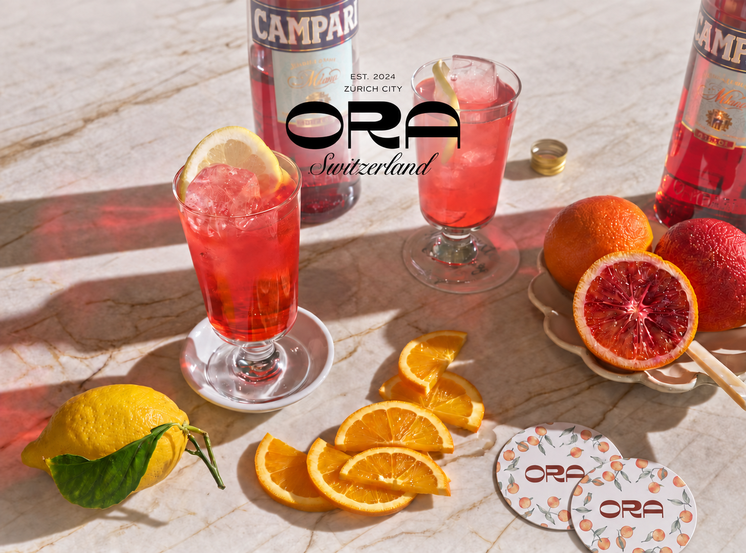 ORA Bar — Campari cocktails with citrus and ORA coasters in bright daylight